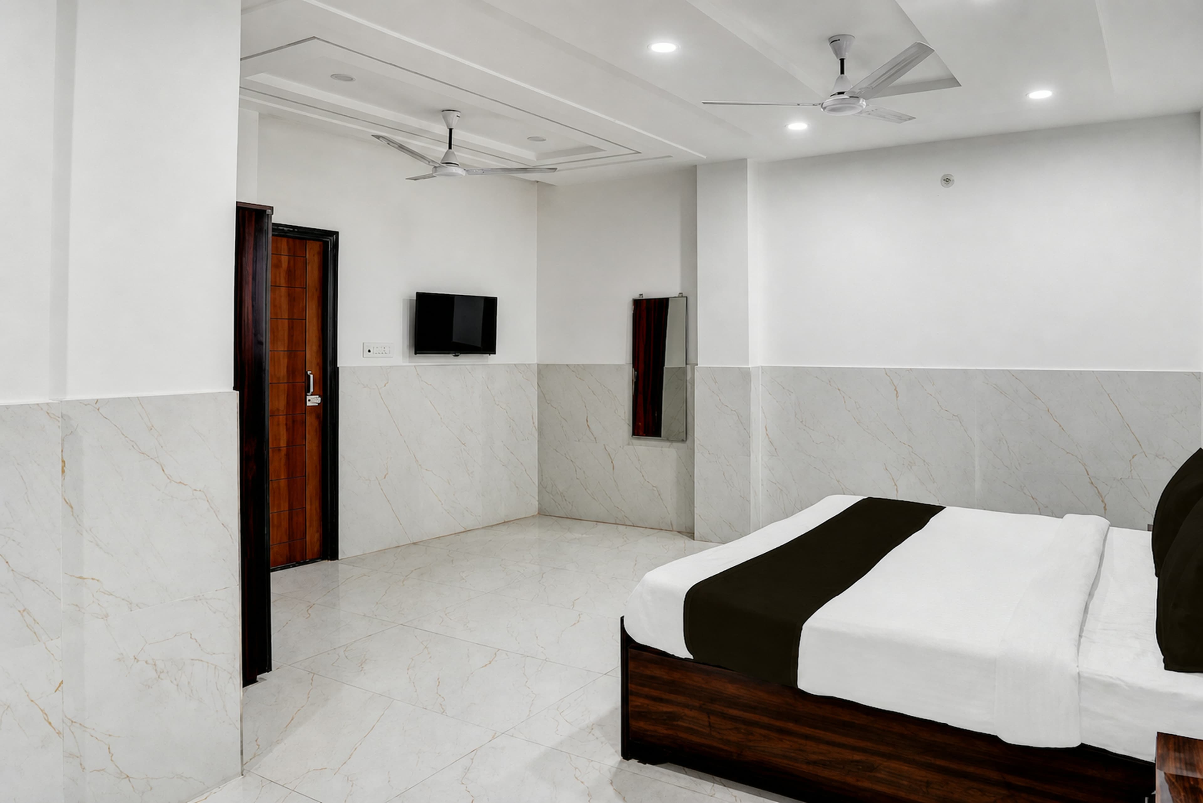 AC guest room with fresh linen and a wall-mounted TV